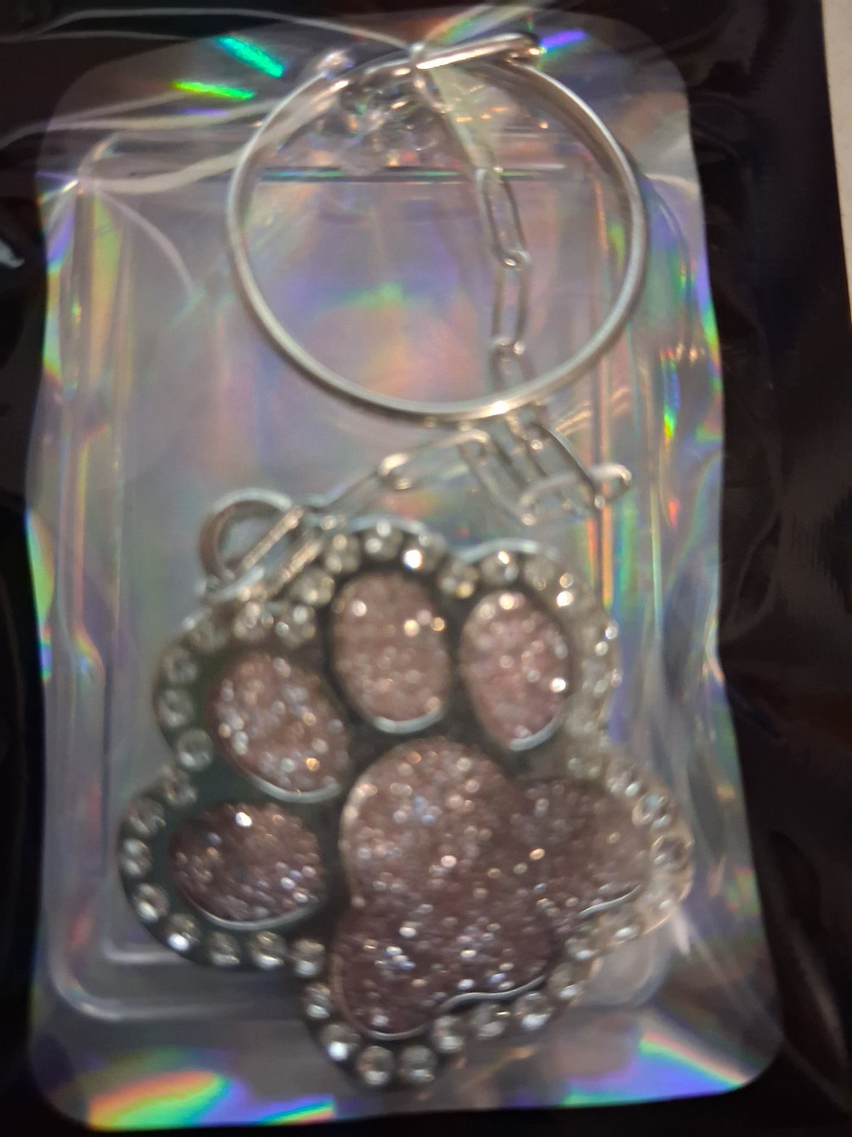 Pink glitter paw charm keyring in its holographic gift bag