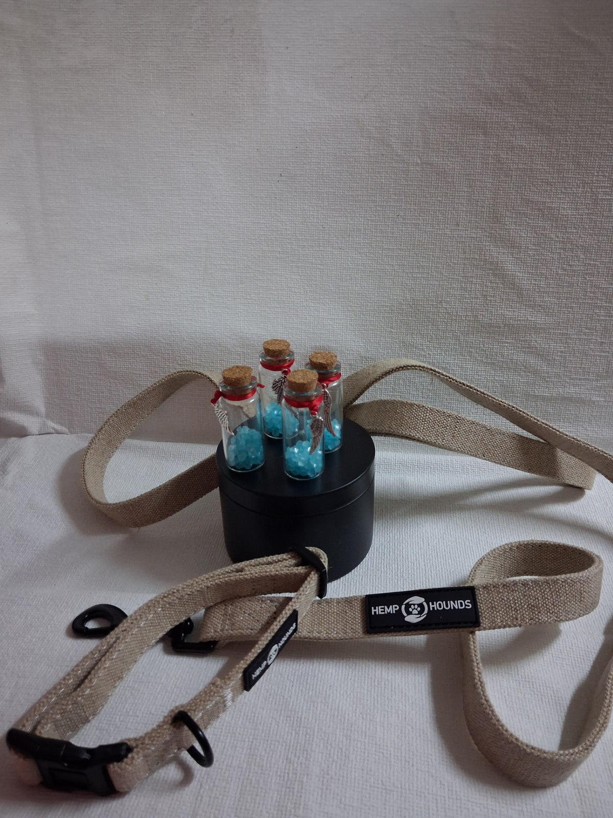 Memorial keepsake bottles with blue stones displayed on a black round box